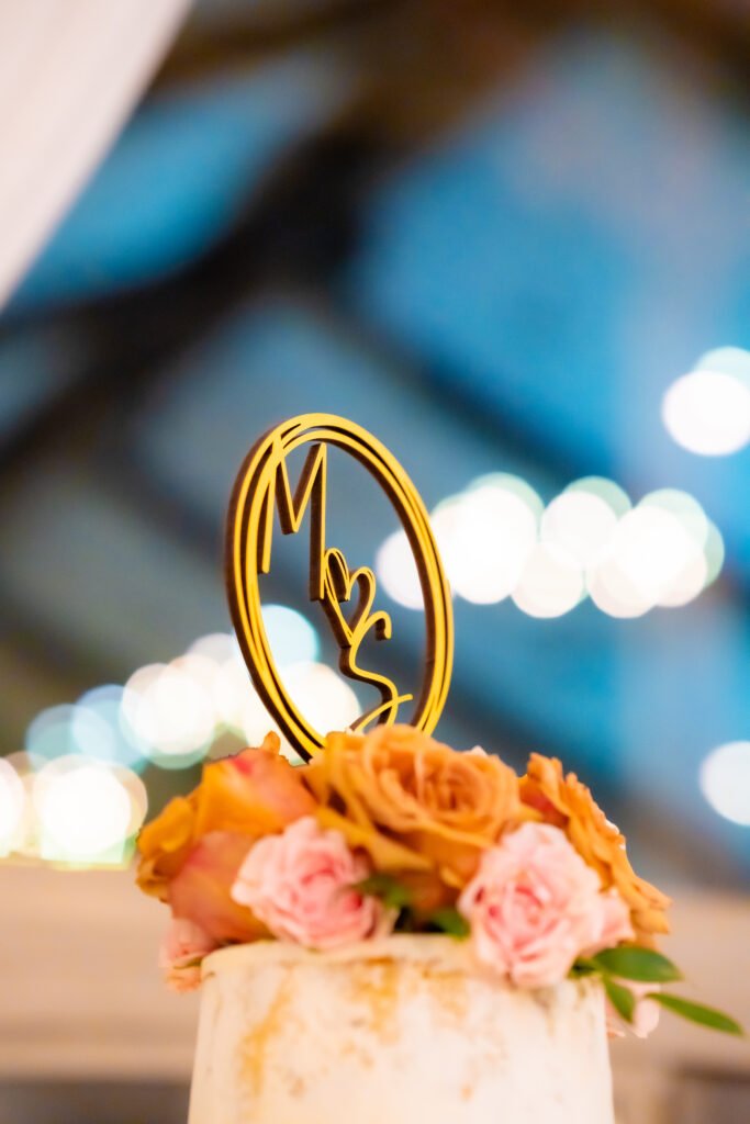 Luxury wedding monogram centerpiece with gold acrylic initials and floral decor at an elegant wedding reception.